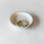 8mm Alaskan Avocado  (a green color) with fresh water pearl and gold spacers in a bracelet form.  