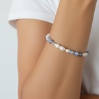 The Jodi Bracelet — Blue Fire Agate, Moonstone, and pearl stretch bracelet by Poppies & Jules. shown on a wrist.