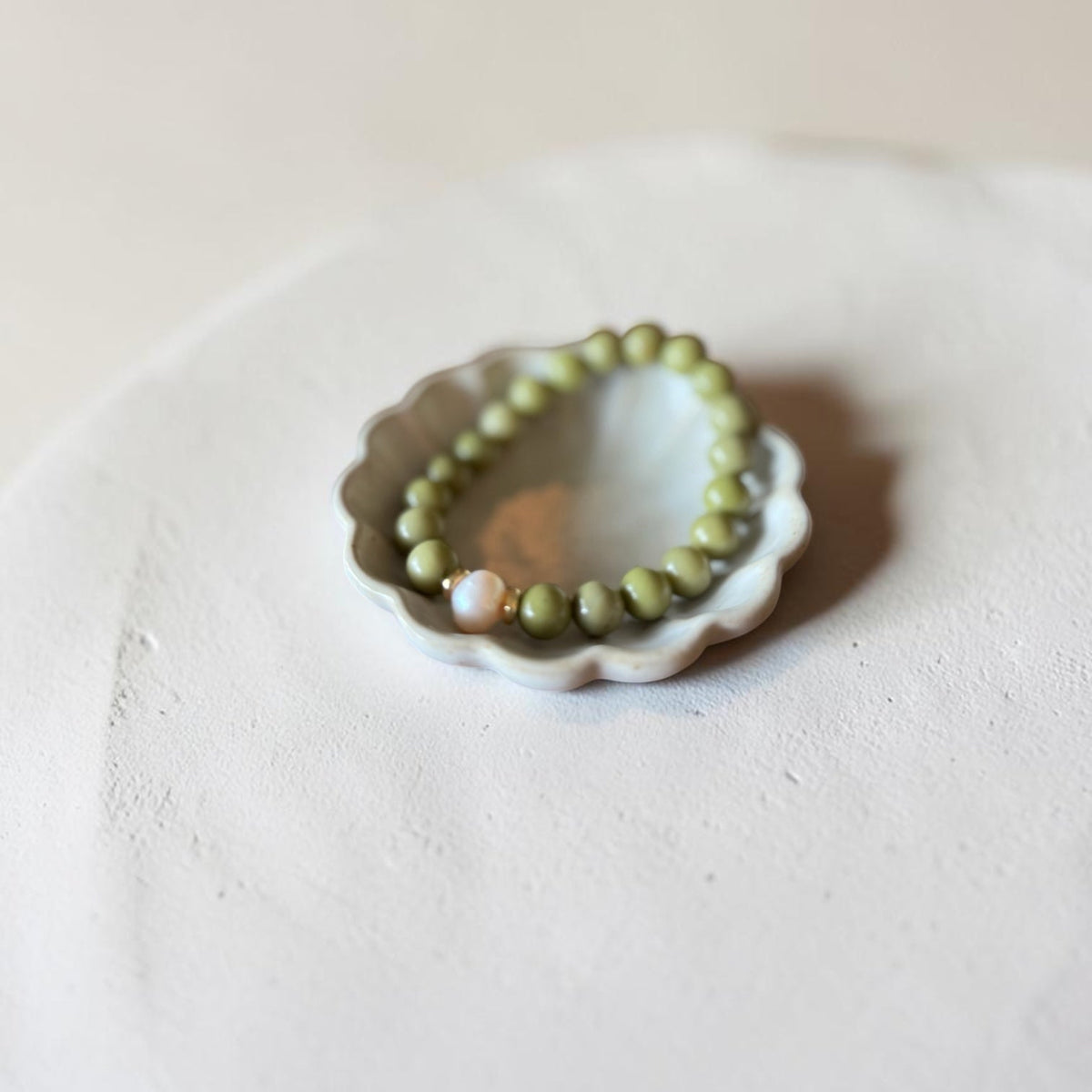 8mm Alaskan Avocado  (a green color) with fresh water pearl and gold spacers in a bracelet form.  
