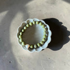 8mm Alaskan Avocado  (a green color) with fresh water pearl and gold spacers in a bracelet form. 
