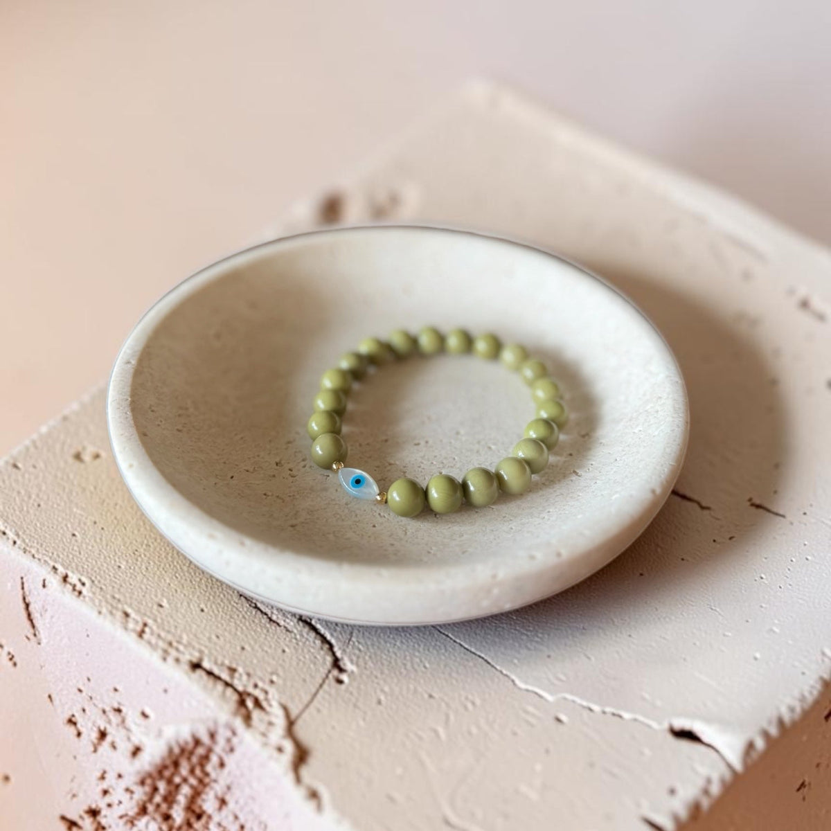 Close-up of The Romy Bracelet showing the mother of pearl evil eye charm and gold filled beads — Poppies & Jules