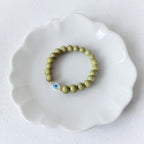 Close-up of The Romy Bracelet showing the mother of pearl evil eye charm and gold filled beads — Poppies & Jules