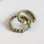 8mm Alaskan Avocado  (a green color) with fresh water pearl and gold spacers in a bracelet form.  Also paired with another bracelet in the same stone with evil eye accent. 