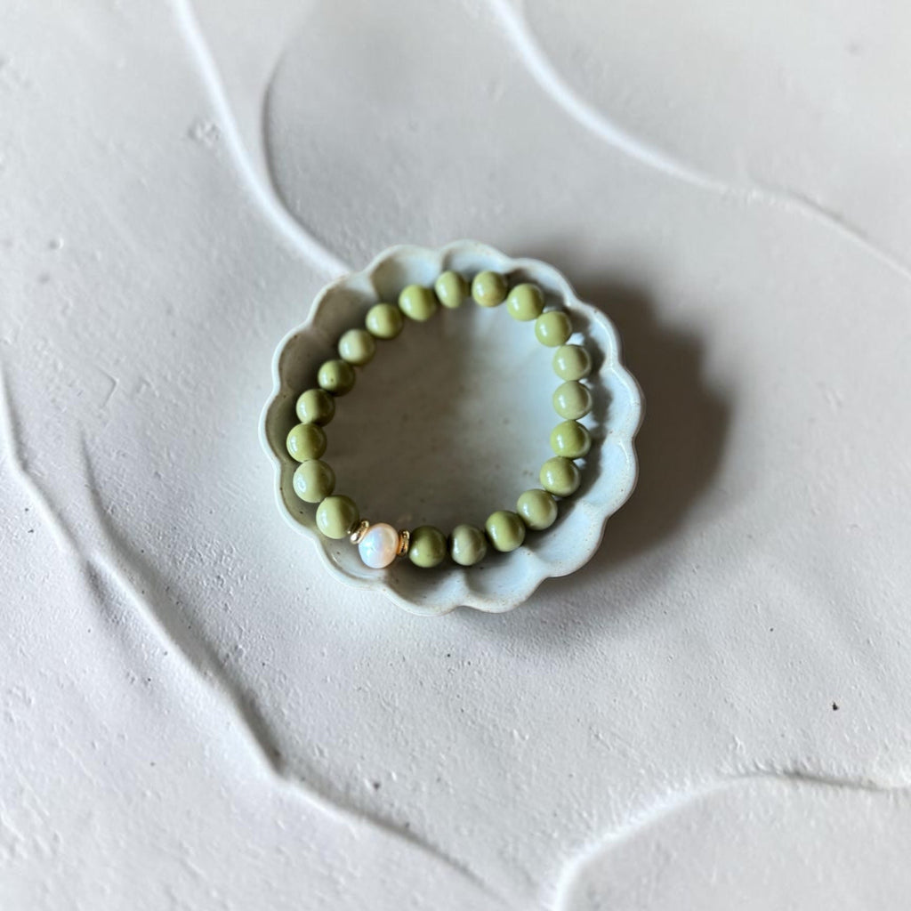 8mm Alaskan Avocado  (a green color) with fresh water pearl and gold spacers in a bracelet form.  