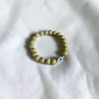 Close-up of The Romy Bracelet showing the mother of pearl evil eye charm and gold filled beads — Poppies & Jules
