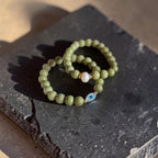 8mm Alaskan Avocado  (a green color) with fresh water pearl and gold spacers in a bracelet form.  Also paired with another bracelet in the same stone with evil eye accent. 