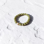 8mm Alaskan Avocado  (a green color) with fresh water pearl and gold spacers in a bracelet form.  