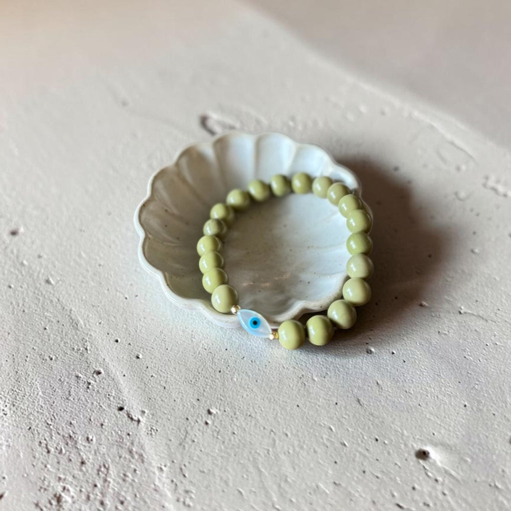 Close-up of The Romy Bracelet showing the mother of pearl evil eye charm and gold filled beads — Poppies & Jules