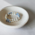 The Jodi Bracelet — Blue Fire Agate, Moonstone, and pearl stretch bracelet by Poppies & Jules. Sitting in a dish.