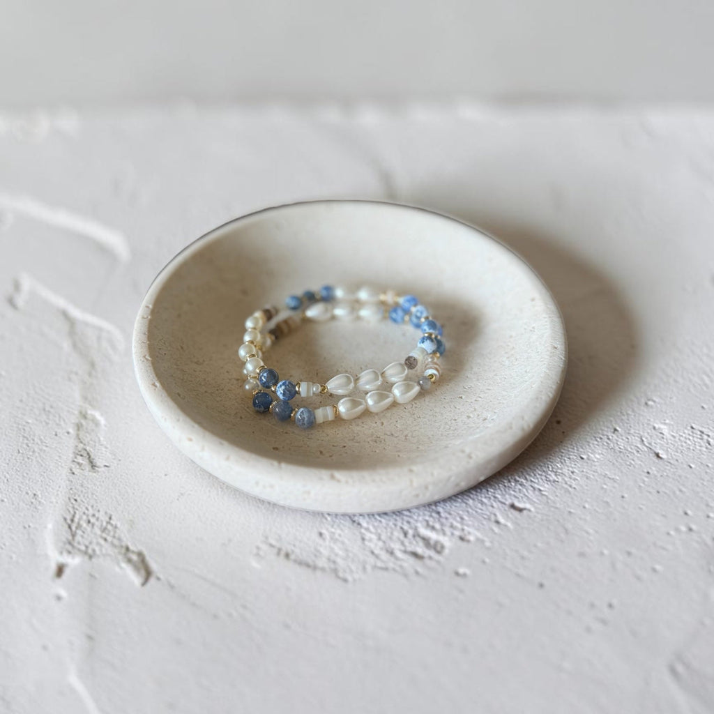The Jodi Bracelet — Blue Fire Agate, Moonstone, and pearl stretch bracelet by Poppies & Jules. Bracelets sitting in dish. 