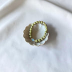 Close-up of The Romy Bracelet showing the mother of pearl evil eye charm and gold filled beads — Poppies & Jules