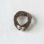 smoky brown bracelets in a stack. With a teardrop pearl and gold filled bead placed on both sides of the pearl.