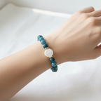 The Arden Bracelet on Wrist. this is a picture of female arm and wrist. In the center is flat circle pearl with gold spacers surrounding each side.