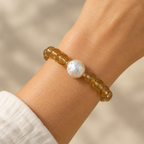 The Beatrice Bracelet worn on a wrist. Fresh water puffy coin pearl accent with amber 8mm beads.