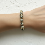 The Bryn Bracelet Wrist Shot sitting close up. Bracelet has spotted beads with wavy gold spacers surrounding the first few beads.