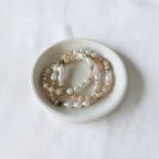 The Jules Bracelet flat lay in a ceramic dish. there are 3 bracelets with differnet looks of beads, spacers and accents.
