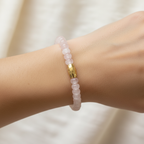 The Lila Bracelet on wrist. This is a close up of an arm. The light pink rondlle beads and gold barrel accent is front in center.