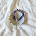 The Meghan Bracelet . This is an amethyst bead bracelet with an unique pearl. Surrounded gold filled beads. This bracelet is in a dish.