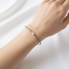The Tide Bracelet - wrist shot of a blue seed bead wire bracelet with pearl nugget.